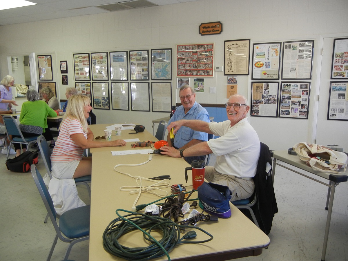 4. Sharon Poland gets her electrical cord repaired by Murray Smith and Phil Antonsen
